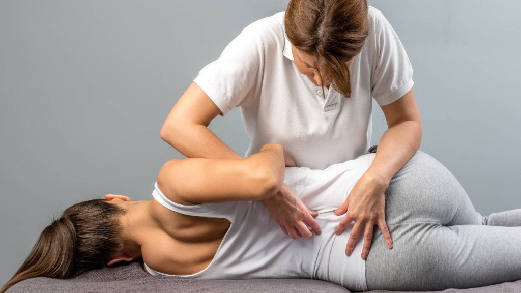 Young woman spinal manipulation by chiropractor